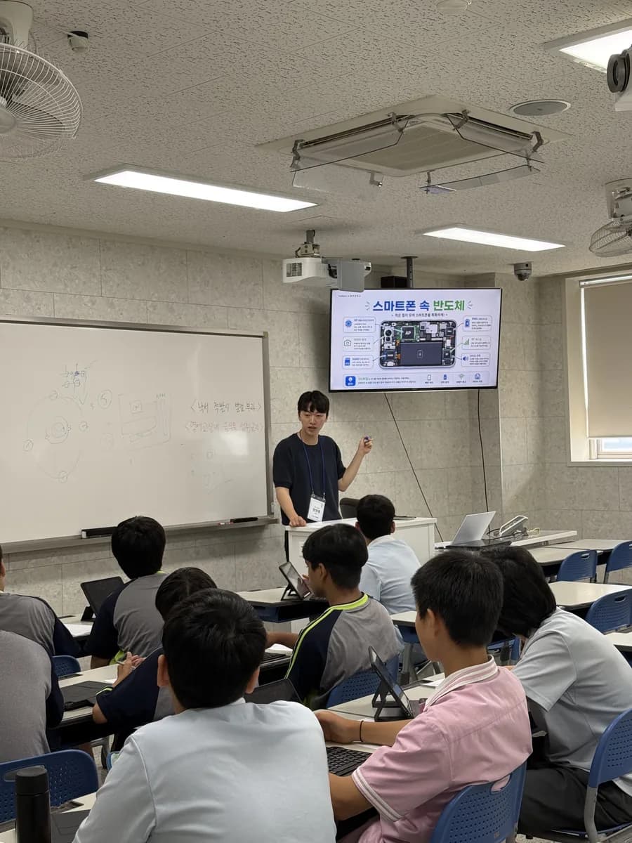 중학교 교실에서 멘토가 발표 자료를 설명하는 모습