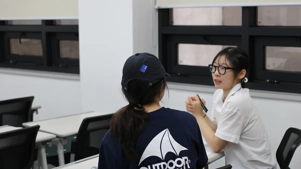 강의실에서 멘토와 학생이 마주 앉아 이야기하는 모습