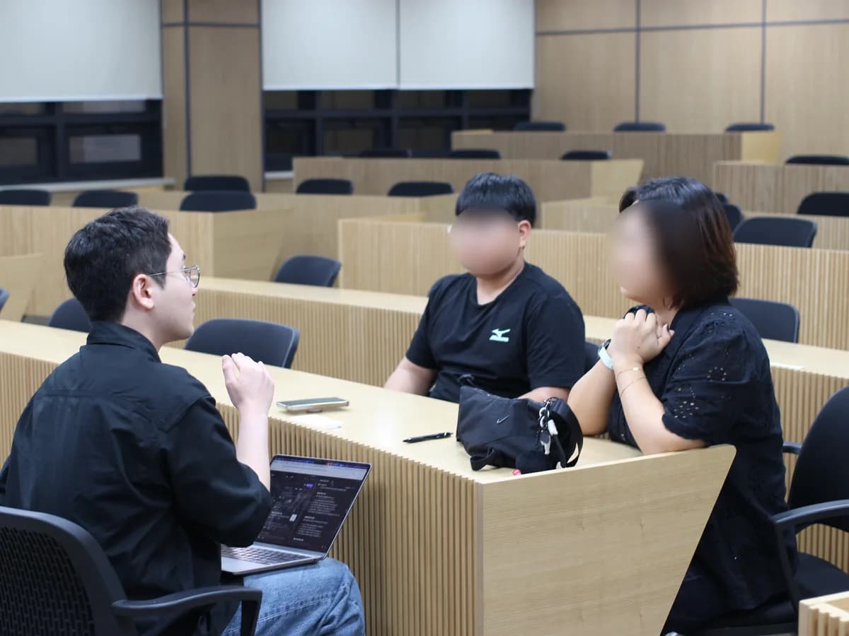 강의실에서 멘토가 학생·보호자와 마주 앉아 상담하는 모습