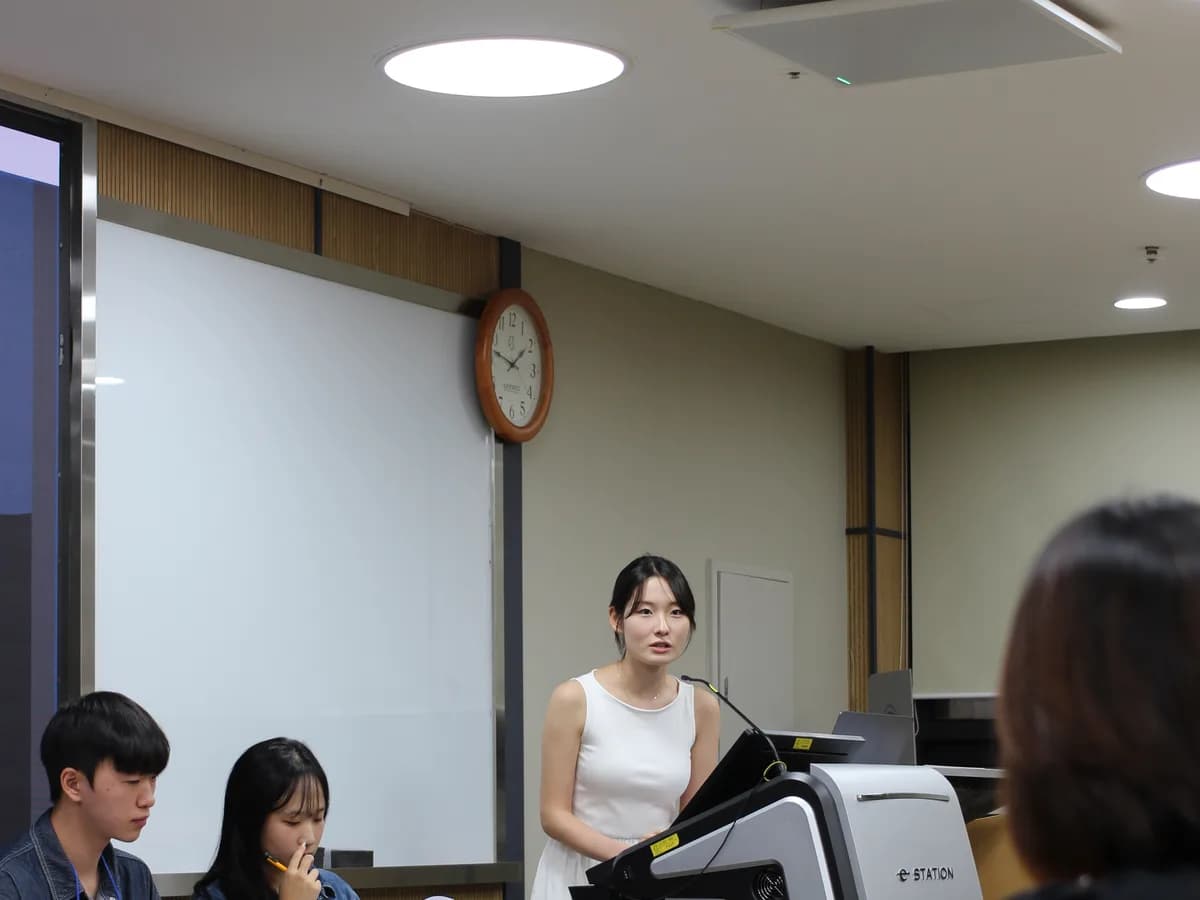강의실 연단에서 멘토가 학생들에게 이야기하는 모습