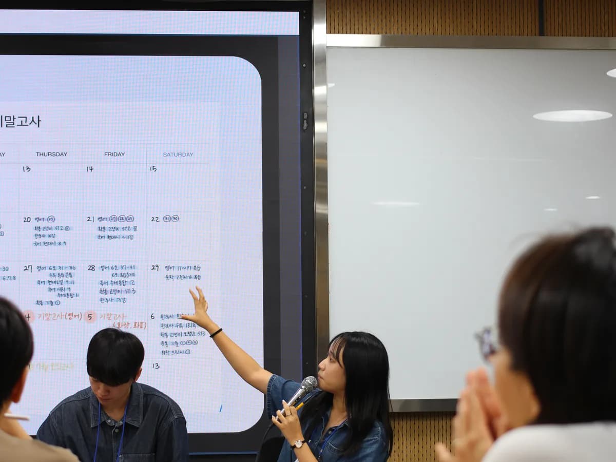 멘토가 화면의 학습 계획표를 가리키며 설명하는 모습
